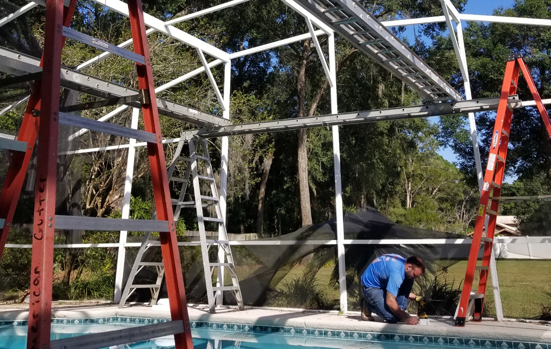 Worker installing a screened enclosure