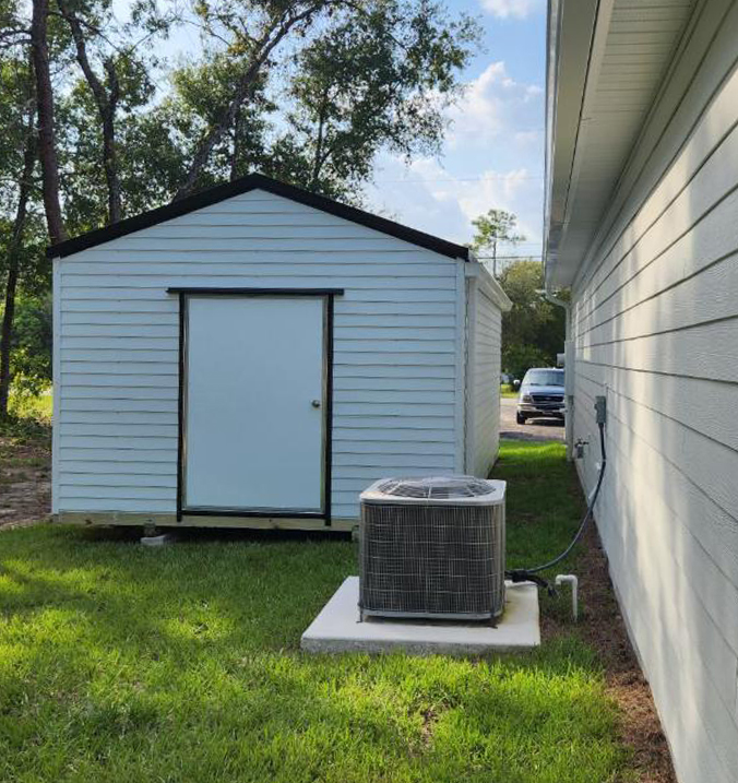 Shed installed in side yard next to house