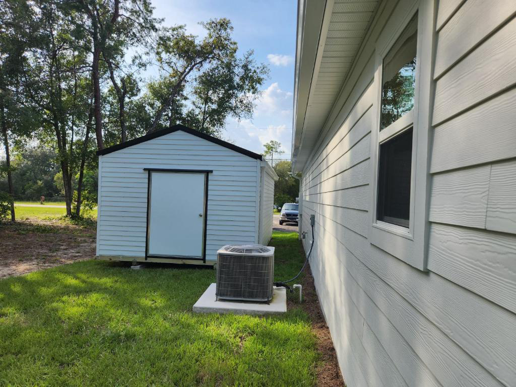 Shed installed in side yard next to house